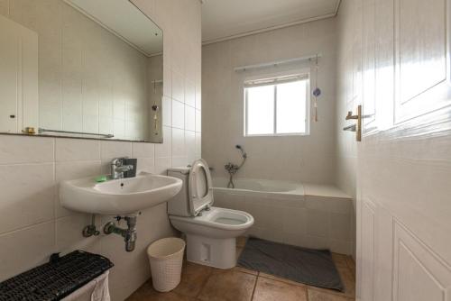 Un baño con inodoro, lavabo y bañera. en On The Beach 19 - Sea View Apartment, en Swakopmund