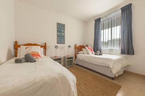 Un dormitorio con dos camas y una ventana. en On The Beach 19 - Sea View Apartment, en Swakopmund