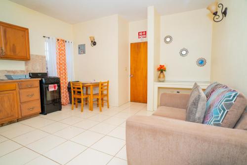 a living room with a couch and a kitchen at Connie's Comfort Suites in Saint Johnʼs