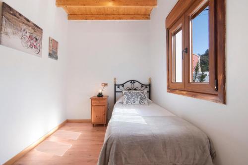 1 dormitorio con cama y ventana en La Tirajanera 1+2, en Vega de San Mateo