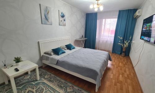 a bedroom with a bed with blue pillows on it at 1 к квартира в Центре Мухита д 128 in Uralsk