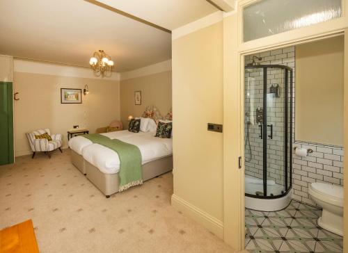 a bedroom with a bed and a bathroom with a shower at Eype's Mouth Country Hotel in Bridport