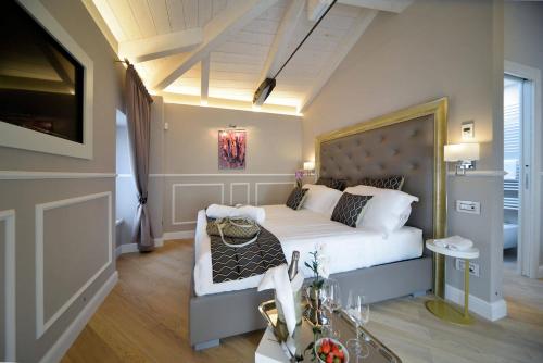 1 dormitorio con 1 cama y sala de estar en Eleìra Luxury Accomodations, en Barolo