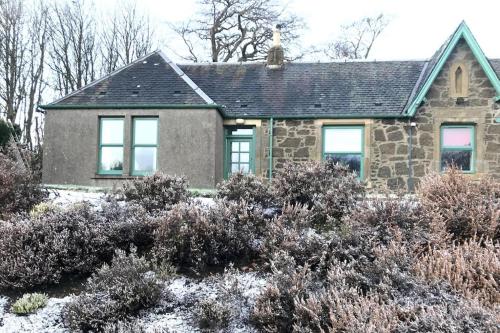 a small stone house with snow on the ground at Cosy Wee Cottage St Andrews 20 in Ceres