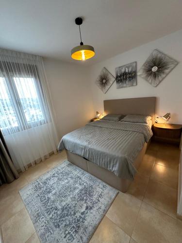 een slaapkamer met een bed en een groot raam bij Esmeralda Suites in Calpe