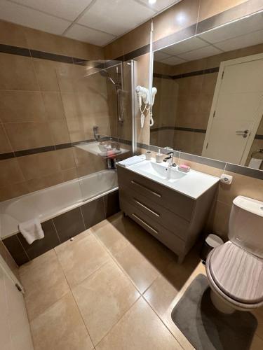 een badkamer met een wastafel, een toilet en een bad bij Esmeralda Suites in Calpe