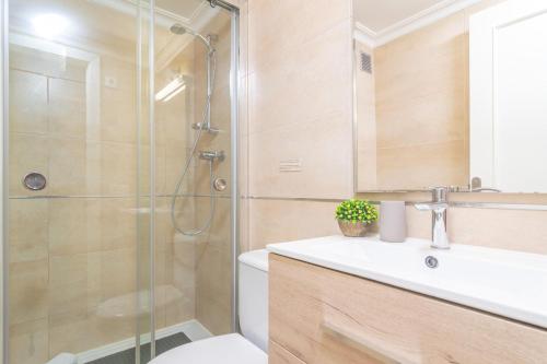 a bathroom with a shower and a toilet and a sink at Novi in Port d'Alcudia