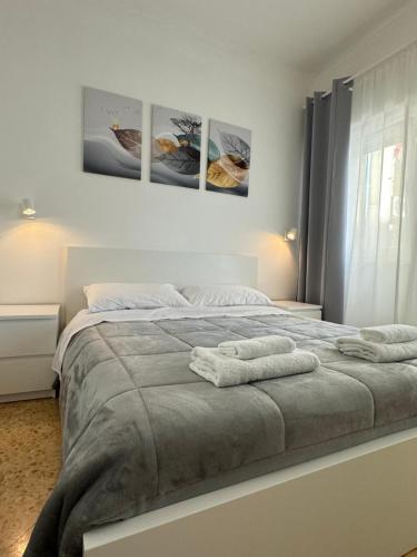 1 dormitorio con 1 cama con 3 cuadros en la pared en Quintino Sella, en Bari