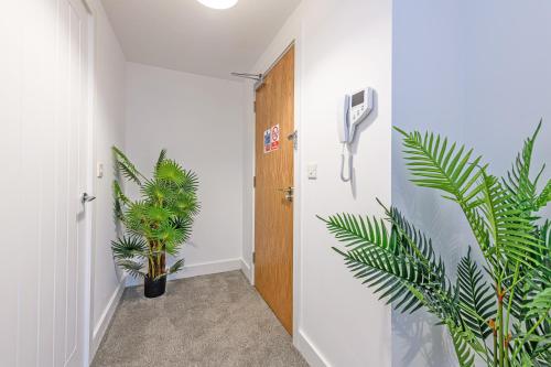 a hallway with a door and a plant at Gospel Heights by Guestz in Heswall