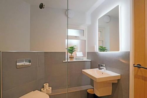 bagno con lavandino, servizi igienici e specchio di Luxurious Modern Retreat a Melbourne