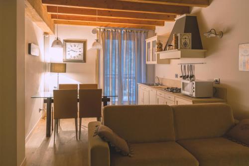 a living room with a couch and a table and a kitchen at AR Mountains Lodge Villachiara in Branzi