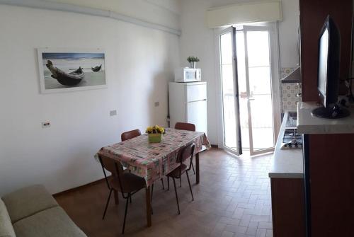 een woonkamer met een tafel en een keuken met een tafel en stoelen bij Appartamento ROYAL in Gatteo a Mare