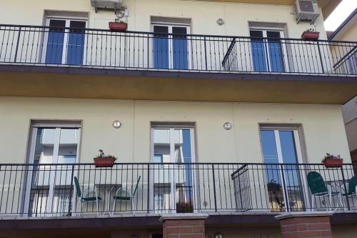 een balkon van een gebouw met stoelen en planten bij Appartamento ROYAL in Gatteo a Mare