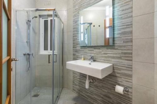 uma casa de banho com um lavatório e um chuveiro em Marsaxlokk Two Bedroom Apartment 1 minute away from the seafront em Marsaxlokk