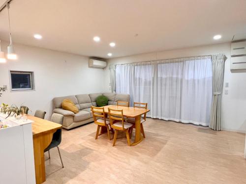 a living room with a couch and a table at Shima Stay holoholo in Zamami