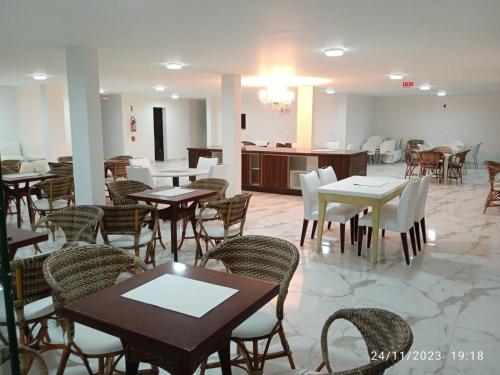 una sala da pranzo con tavoli e sedie in un ristorante di Pousada Pedras do Mariscal a Bombinhas
