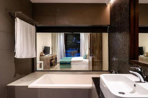 baño con lavabo y espejo grande en Villa Reef Talpe, en Talpe