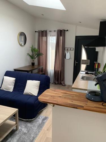 un salon avec un canapé bleu et une table dans l'établissement My Sweet Home, à Varennes-le-Grand