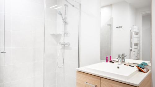 a white bathroom with a sink and a shower at Residhome Nice Aéroport in Nice