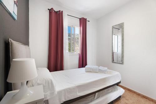 a white bedroom with a bed and a window at La Tablada Atlantic Sea View in Adeje
