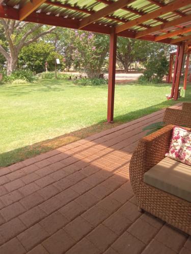 a patio with a couch and a pergola at A Cherry Lane Self Catering and B&B in Bloemfontein