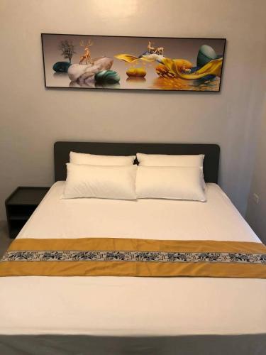 a bed with two pillows and a picture on the wall at COCO STAR HOTEL in Manila