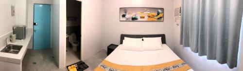 a small bedroom with a bed and a bathroom at COCO STAR HOTEL in Manila