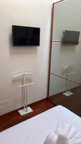 a bedroom with a tv on the wall and a bed at Mantova 4 (trilocale Parma) in Parma