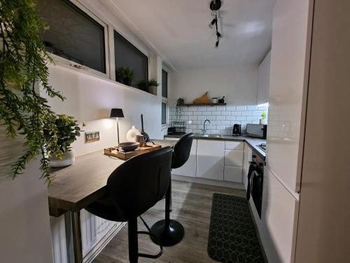 a kitchen with a table and a chair in a room at Spacious and modern flat in Archway in London