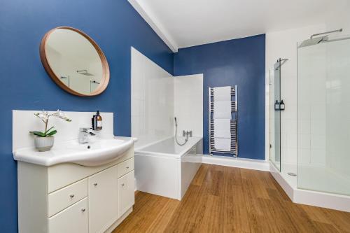 a bathroom with a white sink and a mirror at Ascot House Apartment in Hurstpierpoint