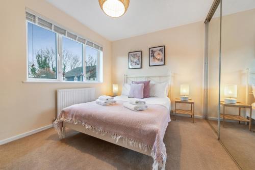 a bedroom with a bed with two lamps and a window at Stylish Short Term Let - Bucks in Bourne End