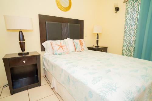 a bedroom with a large bed and two night stands at Connie's Comfort Suites in Saint Johnʼs