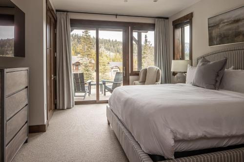a bedroom with a bed and a sliding glass door at Spanish Peaks | Highlands Cabin 30 in Big Sky