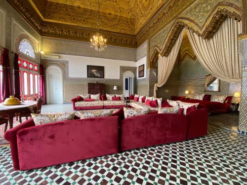 uma grande sala de estar com sofás vermelhos num quarto em Youssef em Fez