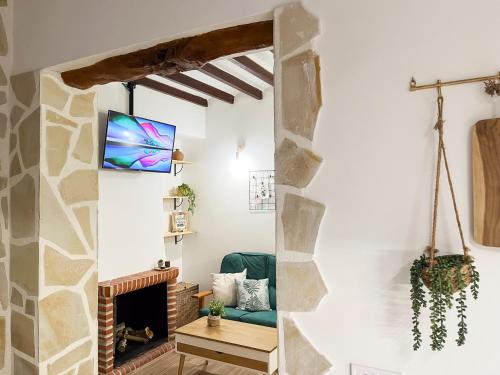 a living room with a fireplace and a tv at Casa Rural La Travesía in Bolulla