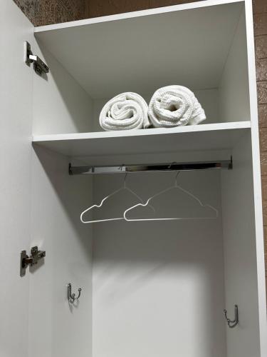 a white cabinet with two towels on a shelf at мини-отель Villa Sofia город Шымкент, проспект Тауке хана, жилой дом 37-2 этаж in Shymkent