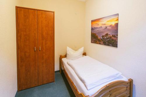 a bedroom with a bed and a wooden cabinet at Gästehaus am Kurpark in Bad Schandau