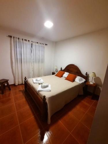 a bedroom with a large bed with towels on it at Nono Huasi Departamentos in Cafayate
