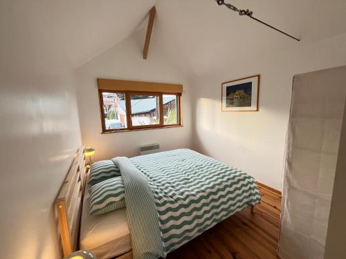 - une petite chambre avec un lit et une fenêtre dans l'établissement Au fil de l'eau - Rivière - Garage pour motos, au Mans