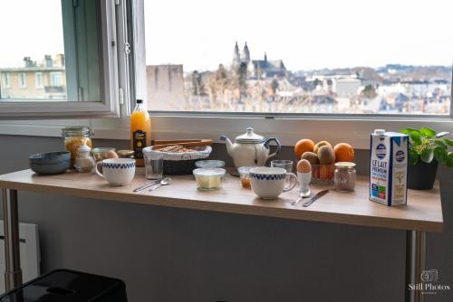 a table with breakfast food on it with a window at Les Beaux Jours, Tours in Tours