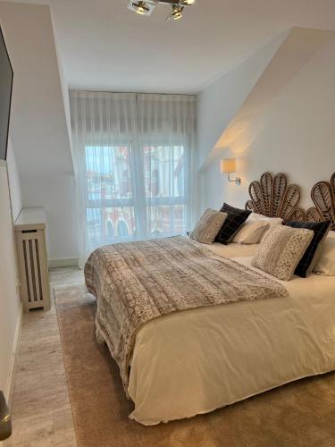 um quarto com uma cama grande e uma janela grande em Apartamento Platas Centro em Ribadesella