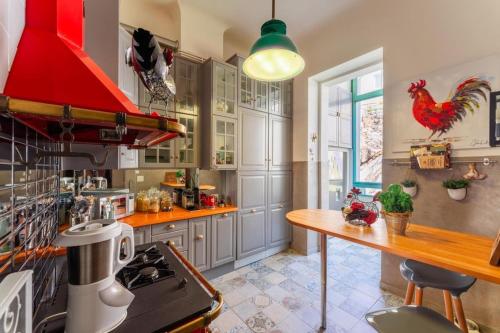 Il comprend une cuisine équipée d'une cuisinière et d'une hotte rouge. dans l'établissement Appartement sur la Corniche Kennedy face à la mer, à Marseille