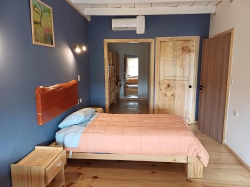 a bedroom with a bed and a blue wall at Aires de Asturias in Puerto Montt