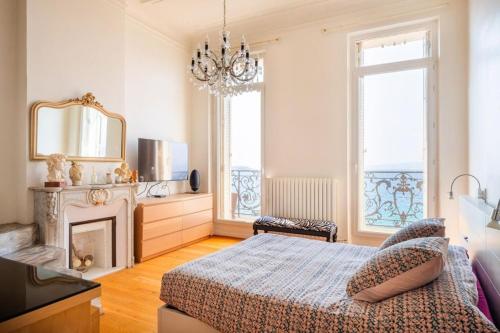 - une chambre avec un lit, une cheminée et un miroir dans l'établissement Appartement sur la Corniche Kennedy face à la mer, à Marseille