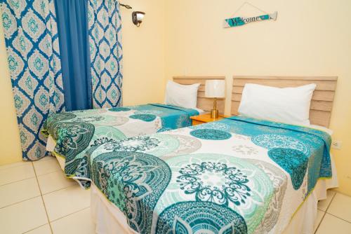 two beds sitting next to each other in a room at Connie's Comfort Suites in Saint Johnʼs