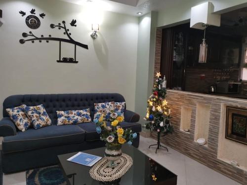 a living room with a blue couch and a christmas tree at 2 bedroom, 4 beds, apartment in El sheikh Zayed Cairo Egypt in Sheikh Zayed