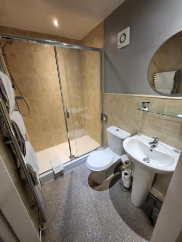 La salle de bains est pourvue d'une douche, de toilettes et d'un lavabo. dans l'établissement Red Lion Inn & Motel, à York
