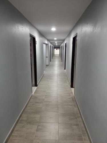 an empty hallway with white walls and a tile floor at La Purisima Hotel in La Paz