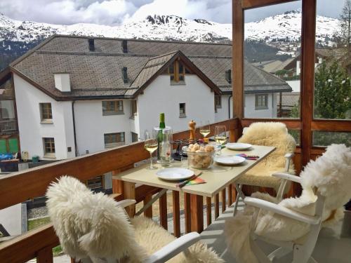 a table and chairs on a balcony with a mountain at Zentral, Ruhig, Sonnig, Modern in Lenzerheide