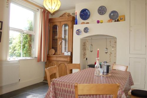 a dining room with a table with a red candle on it at Cadair View Family Holiday Home in Tywyn